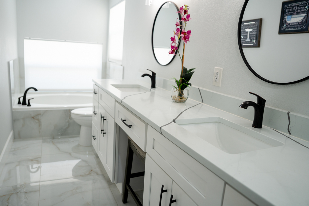 Primary bathroom with double vanity, dual round mirrors and soaking tub