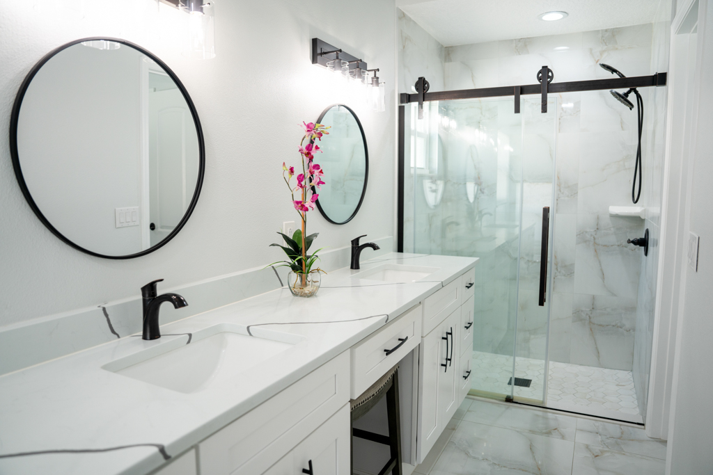 Primary bathroom with double vanity and frameless glass walk-in shower