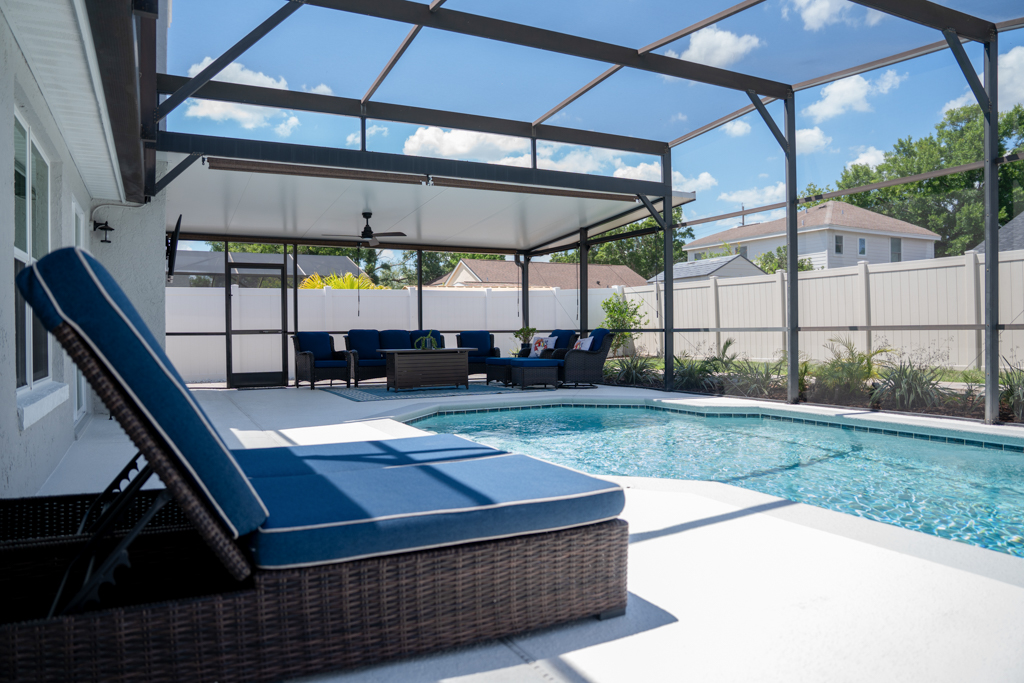 Screened pool with lounge chairs and covered outdoor seating area