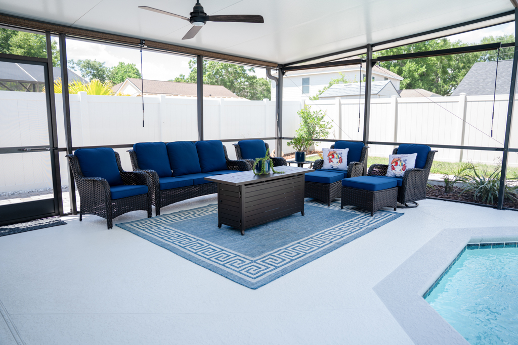 Covered lanai with blue outdoor sofa set and fire pit table