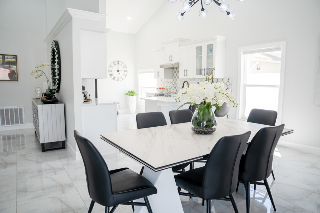 Dining room with marble-top table, black chairs and view to kitchen and living room