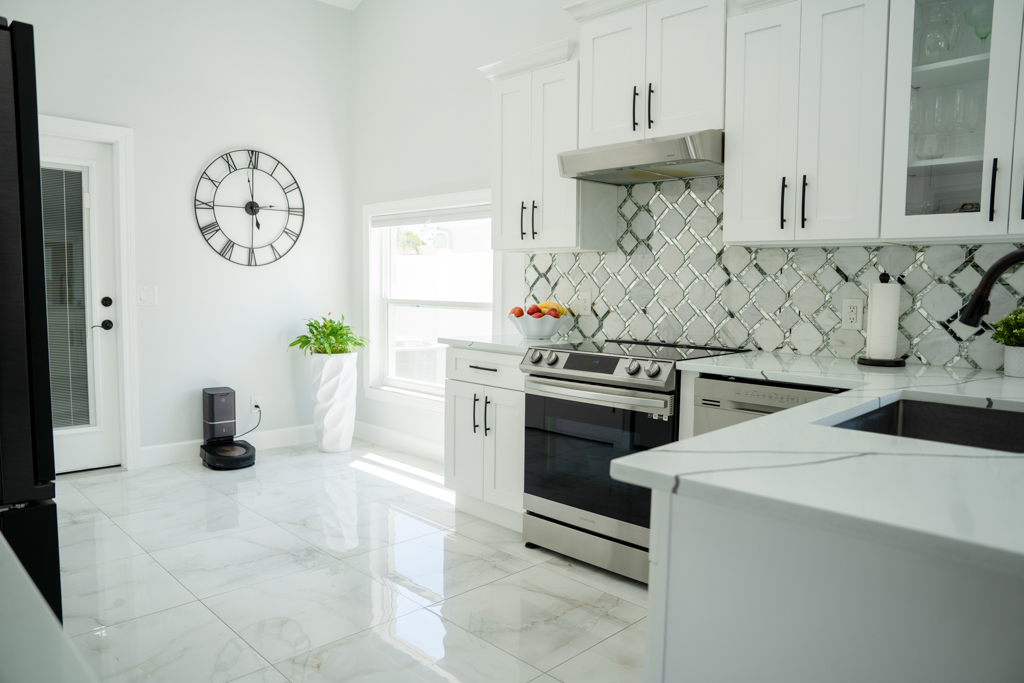 Kitchen with stainless steel range, white cabinets and mirror-tile backsplash