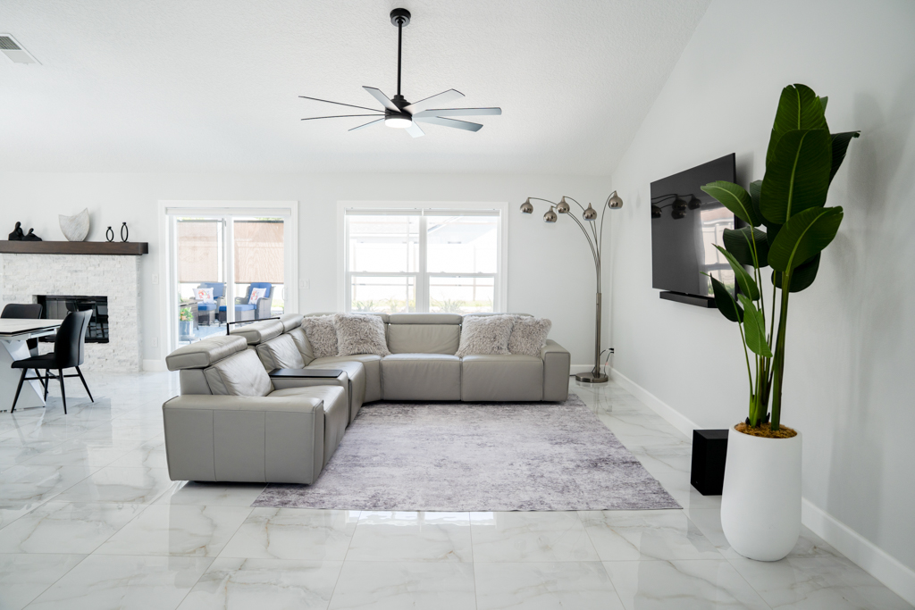 Living room with sectional sofa, wall-mounted TV and stone fireplace