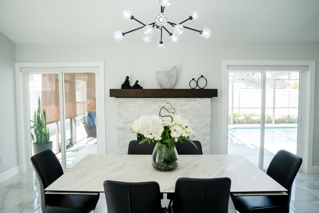 Dining room with marble table, stone fireplace and sliding doors to backyard