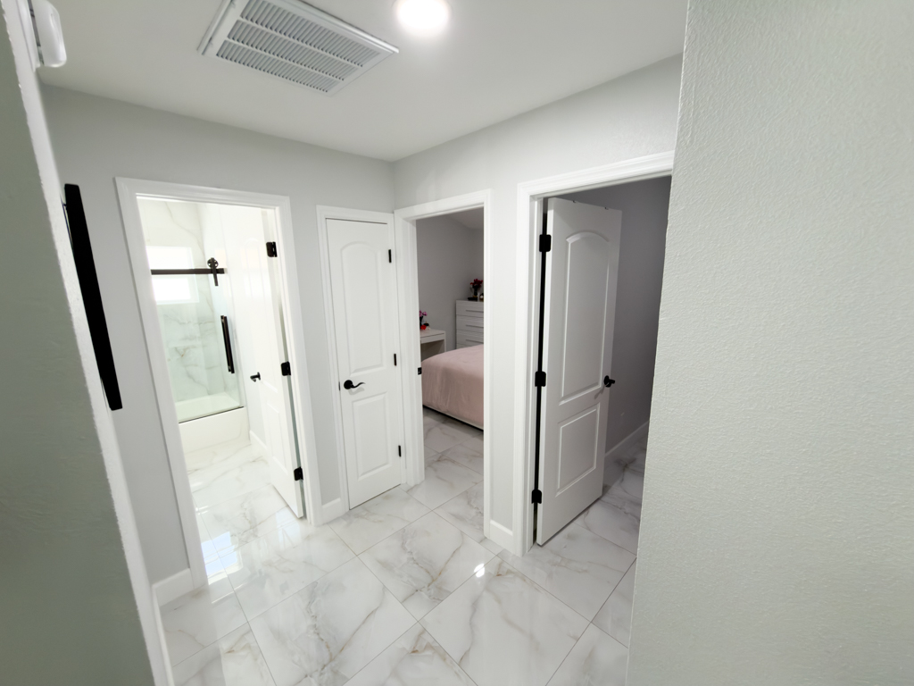 Interior hallway with doors leading to bathroom, bedroom and closet
