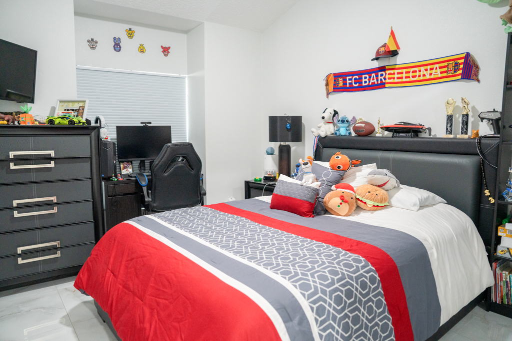 Bedroom with dark furniture, gaming setup and FC Barcelona décor