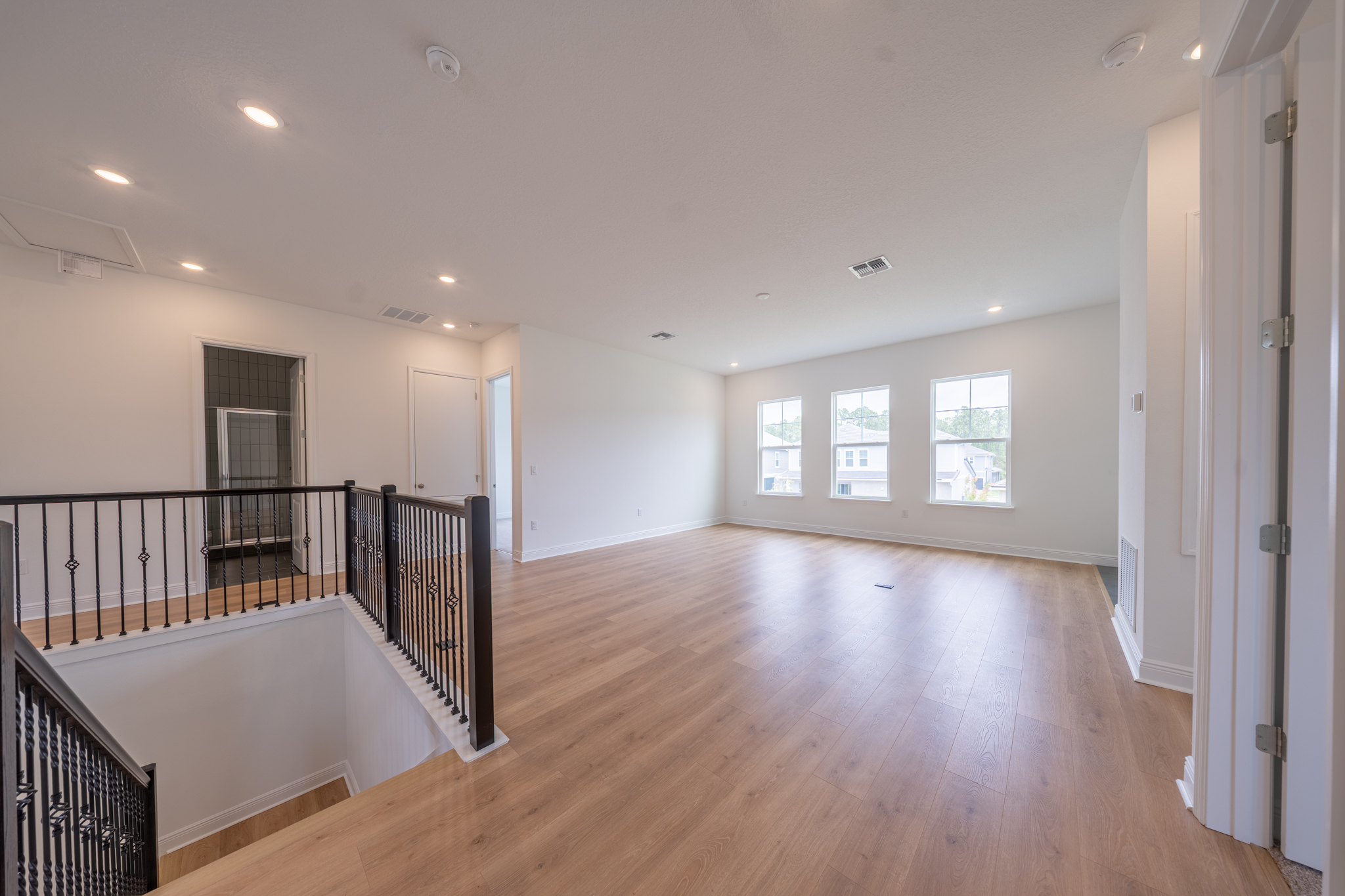 Second-floor loft with iron staircase railing and open view over first floor