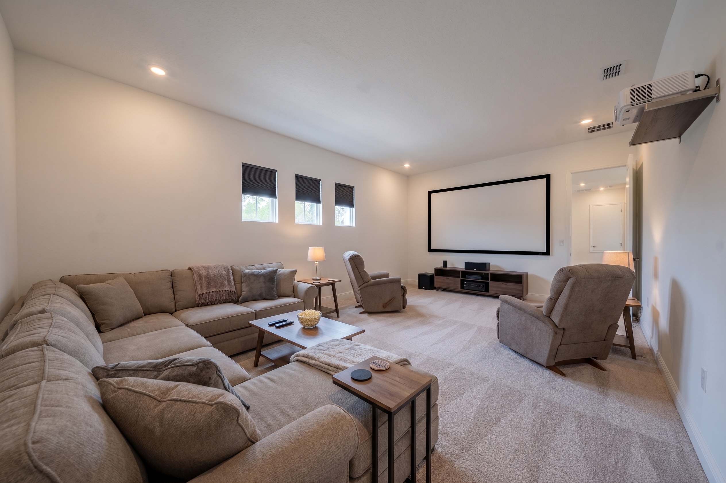 Virtually staged media room with sectional sofa, recliners, projector screen and mounted projector