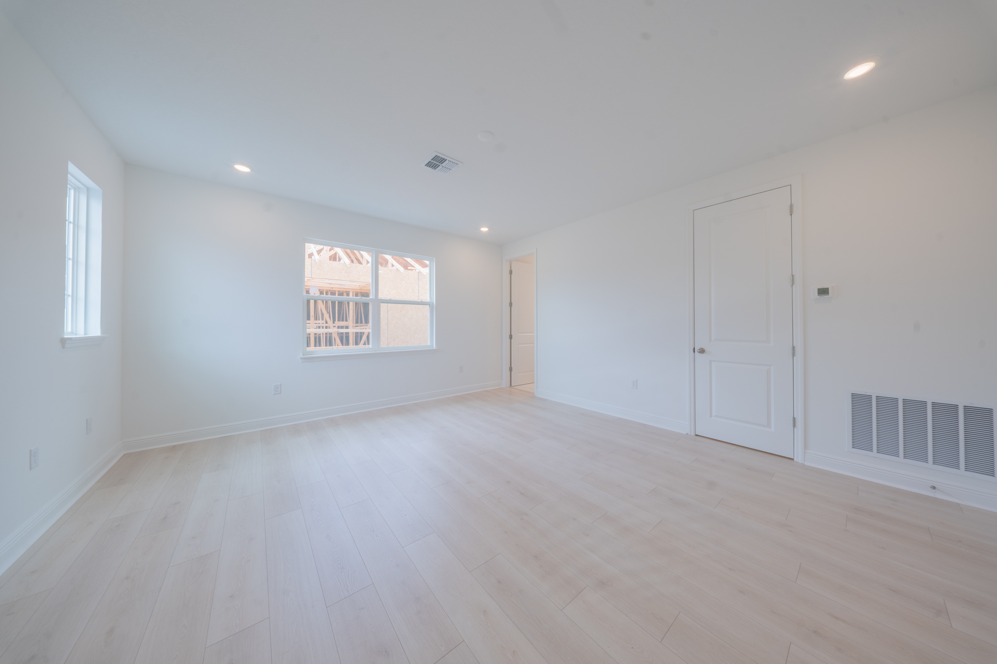Empty room with light hardwood floors and window
