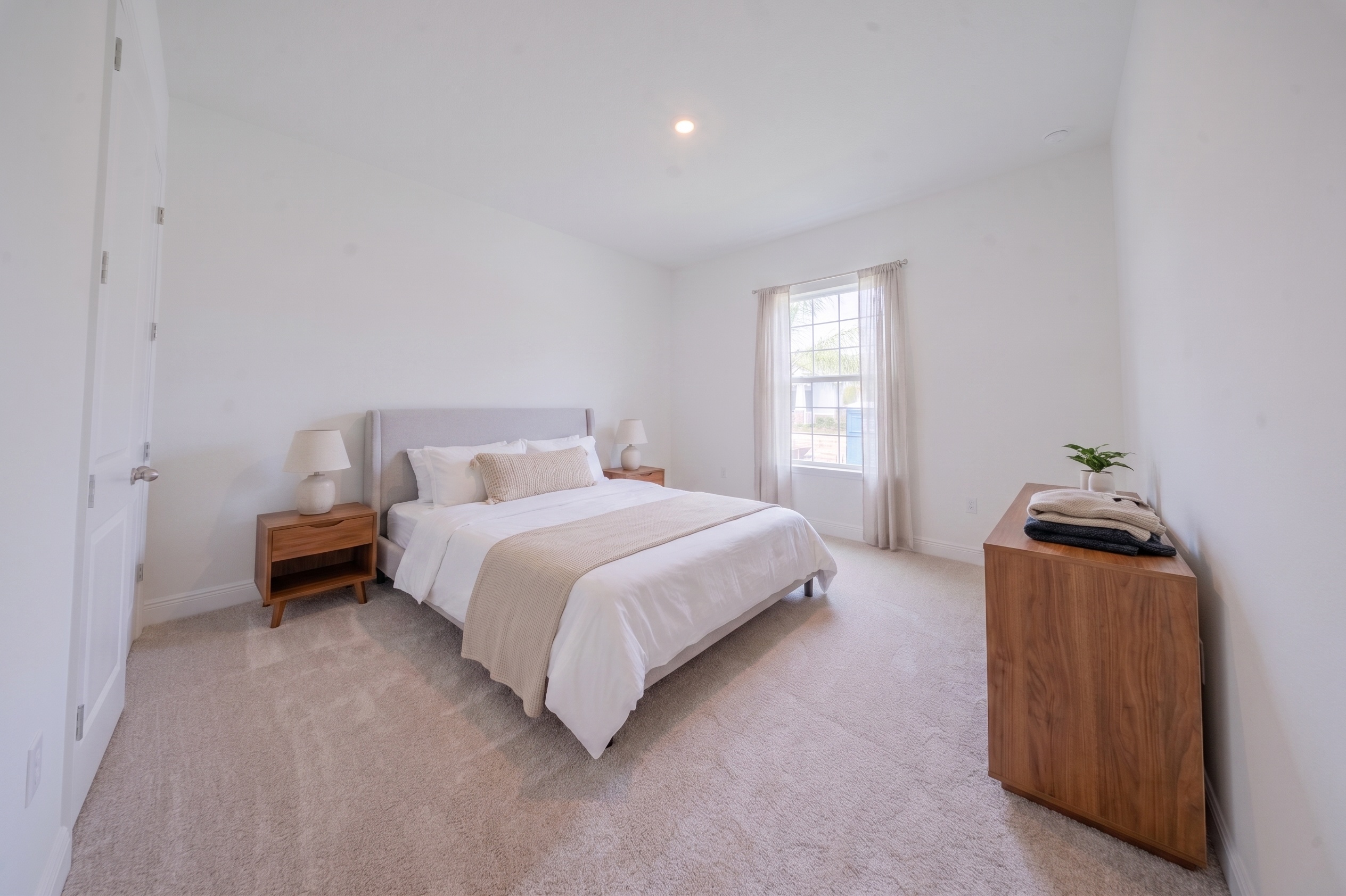Virtually staged bedroom with upholstered queen bed, wood nightstands and dresser