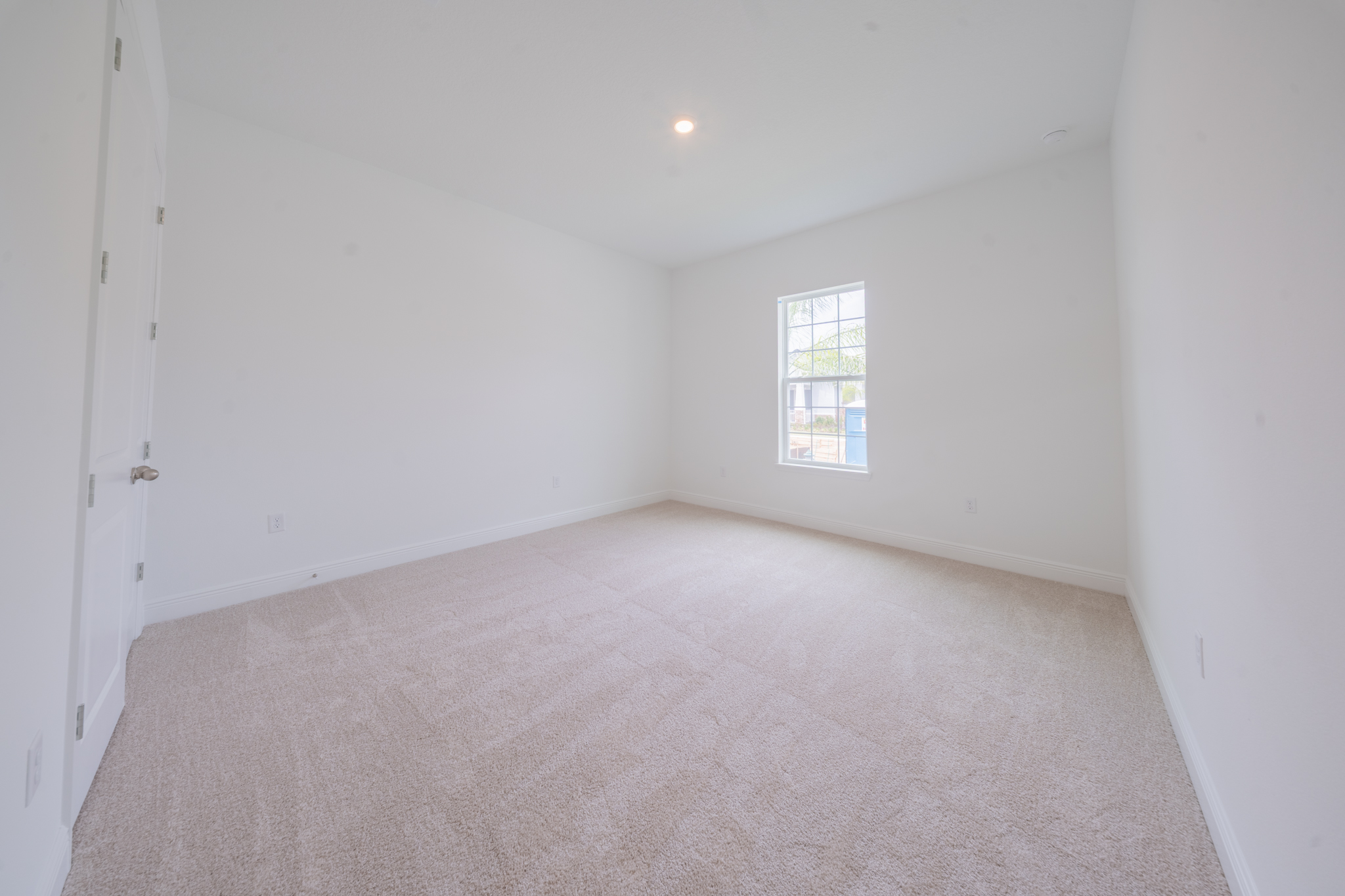 Empty carpeted bedroom with single window