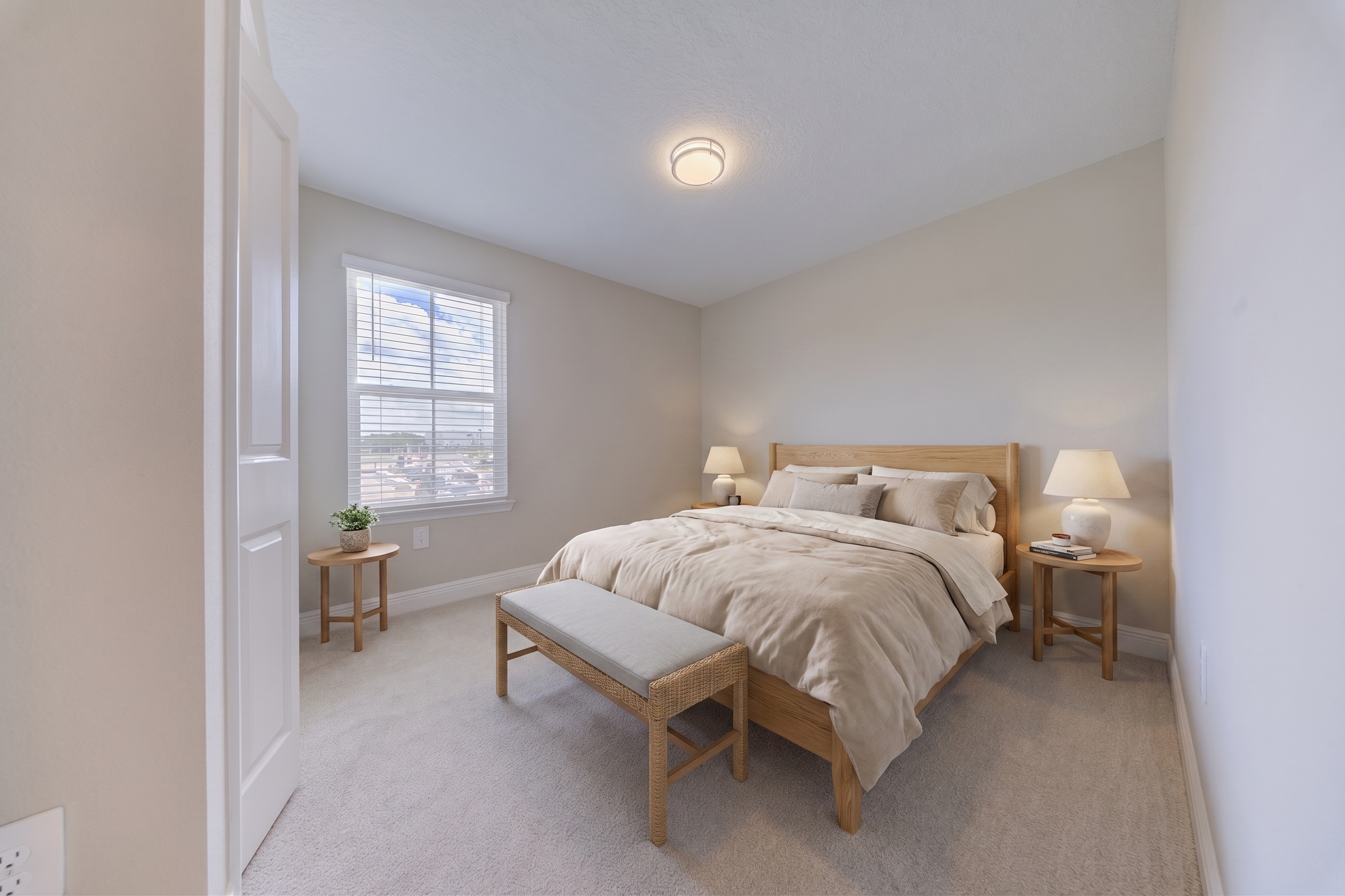 Virtually staged bedroom with wood queen bed frame, matching nightstands, bench and warm neutral tones