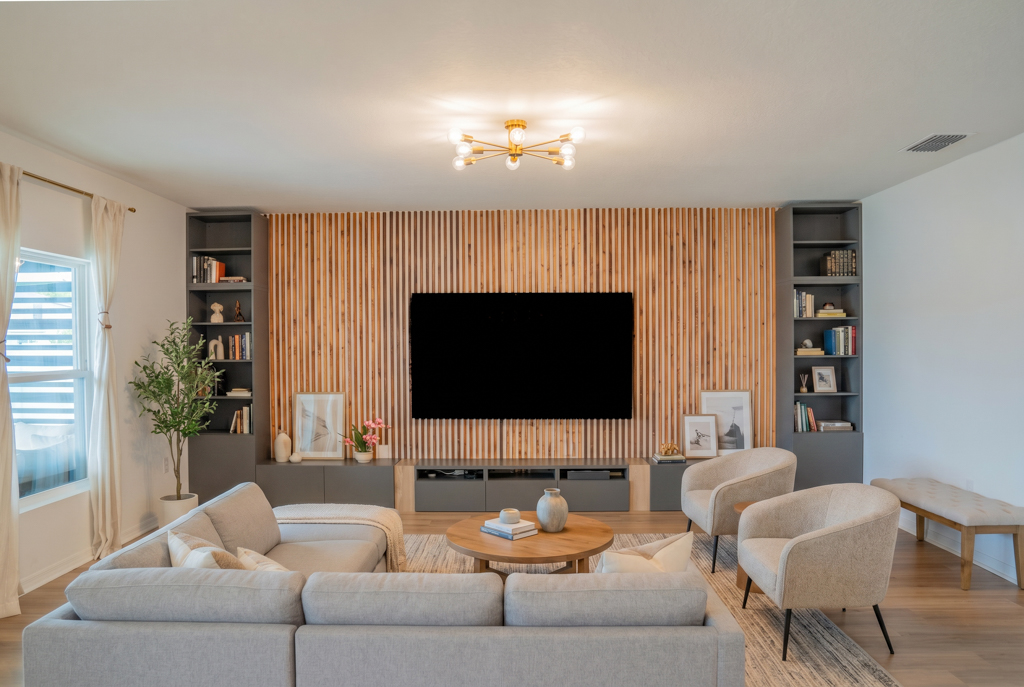 Staged living room with sectional sofa, wood slat TV wall and built-in shelving