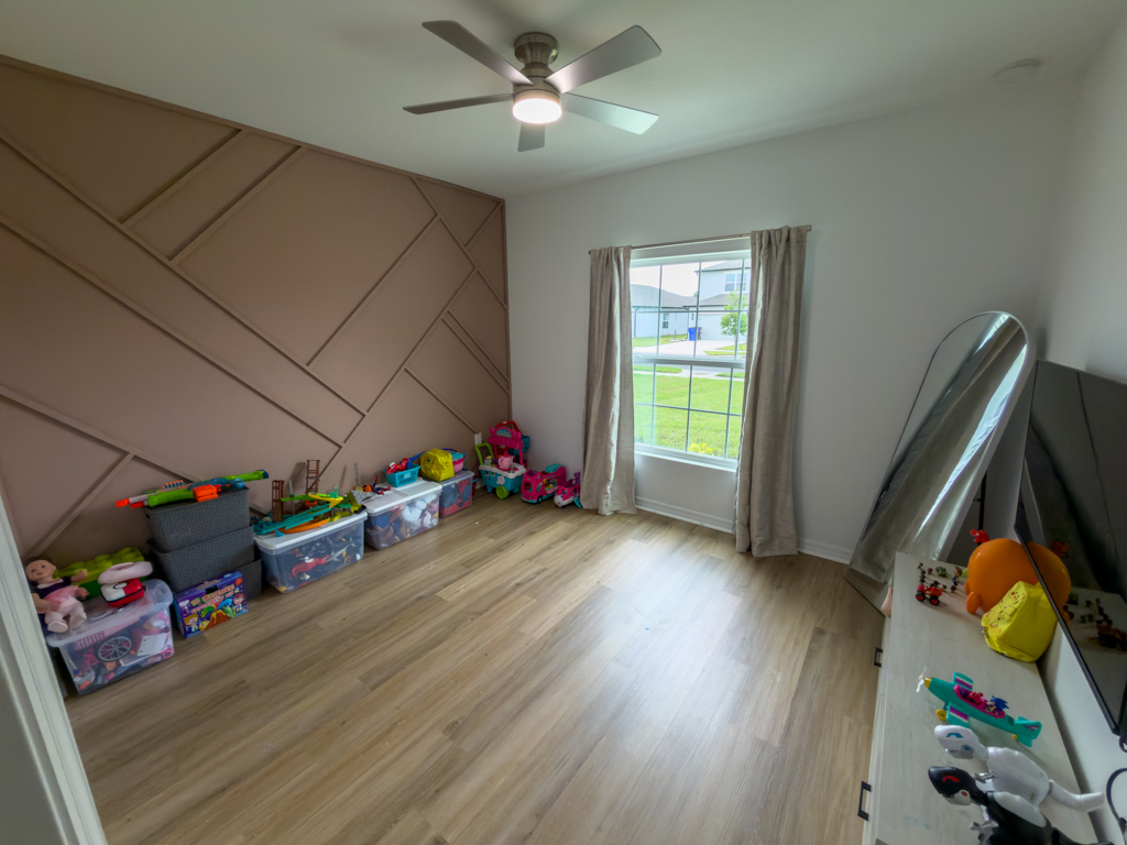 Kids bedroom with pink geometric accent wall and toys