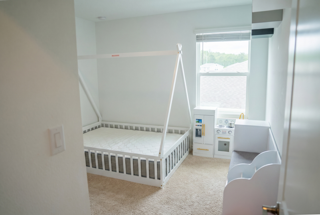 Virtually staged empty toddler bedroom with teepee bed frame and play kitchen