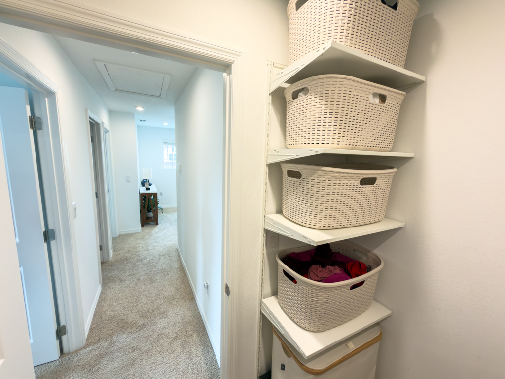 Laundry room hallway with built-in shelving and laundry baskets