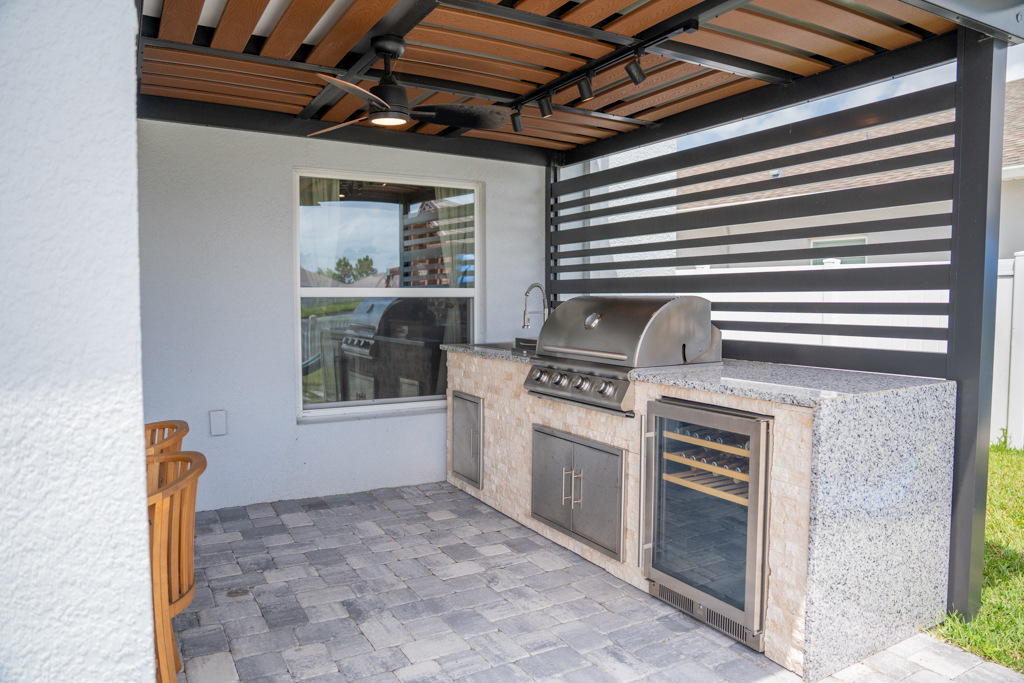 Outdoor kitchen with stainless grill, granite countertop and built-in wine cooler
