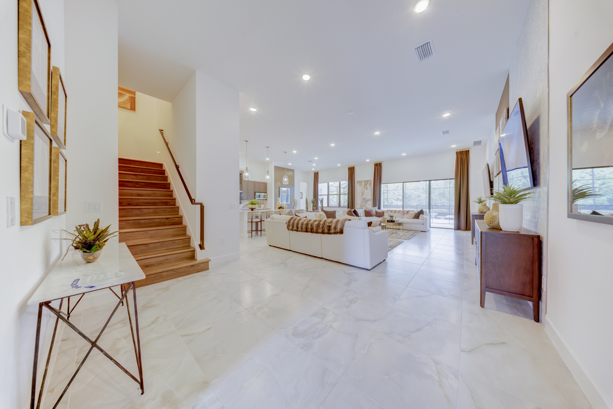 Grand entry foyer with open staircase, marble-look tile floor and open view to great room and kitchen